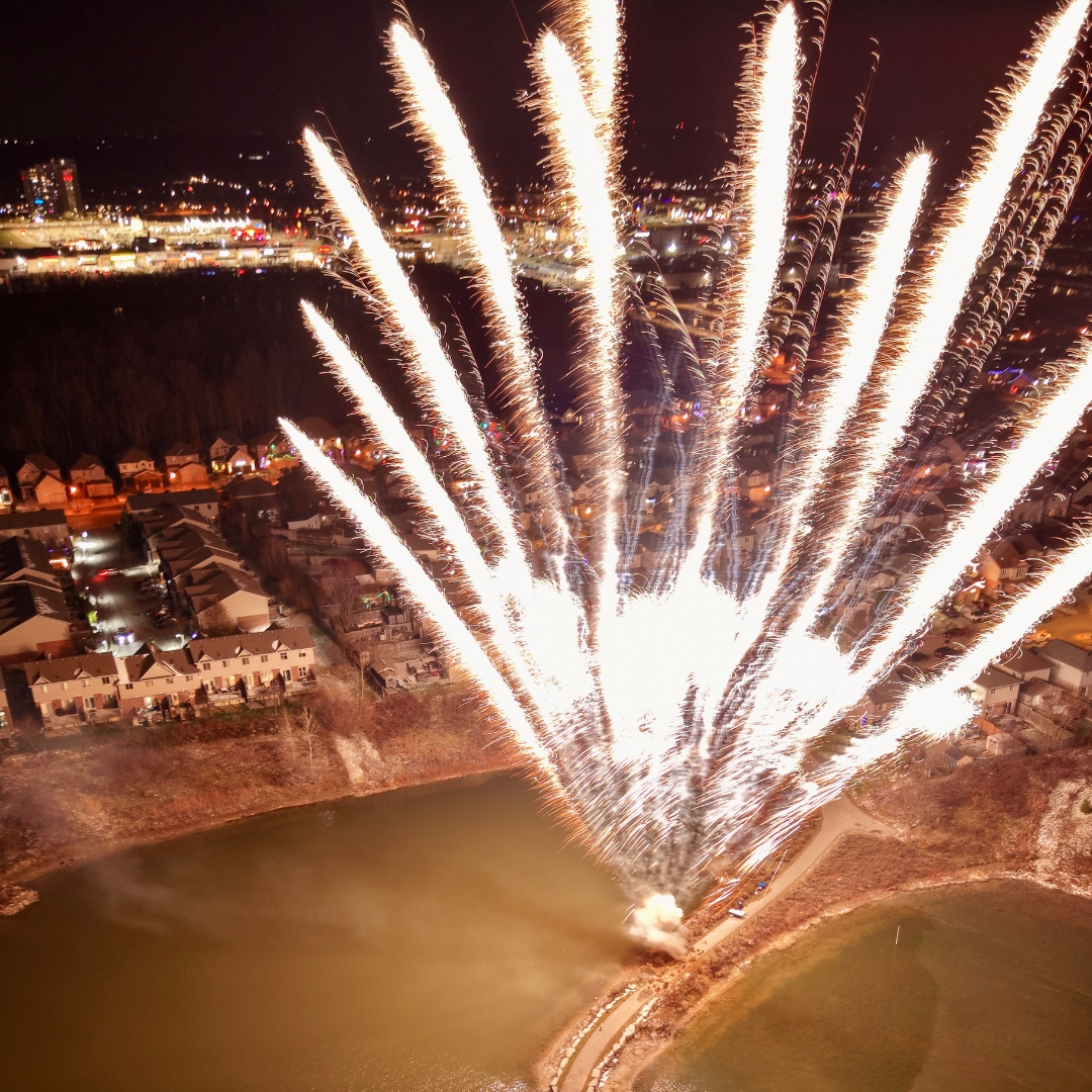 Spectacular low-light drone photography capturing vibrant festival fireworks over a crowd